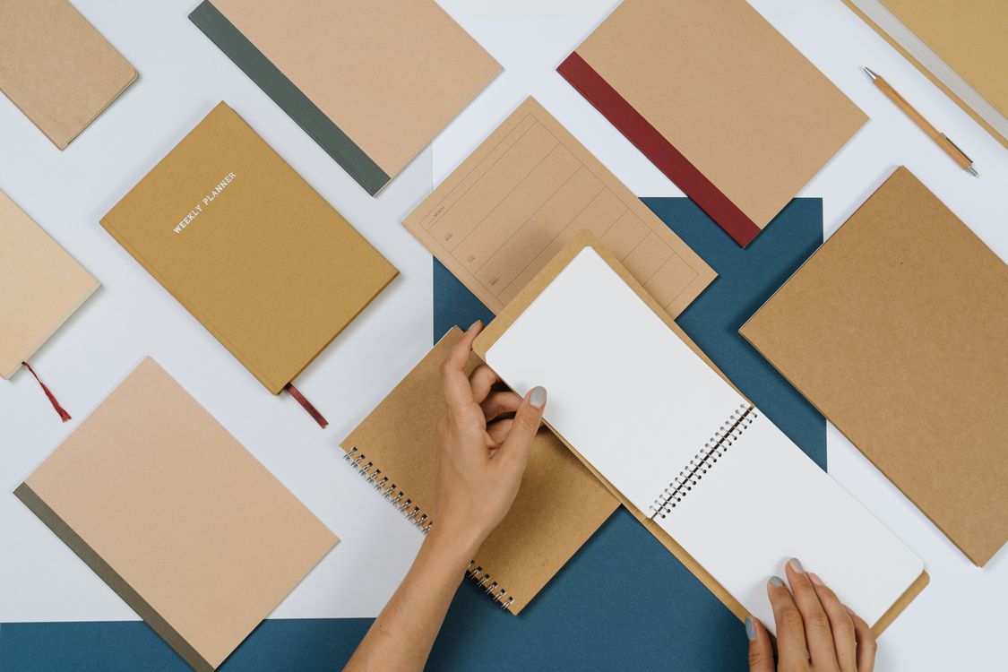 Person flipping notepad pages for content idea bank template