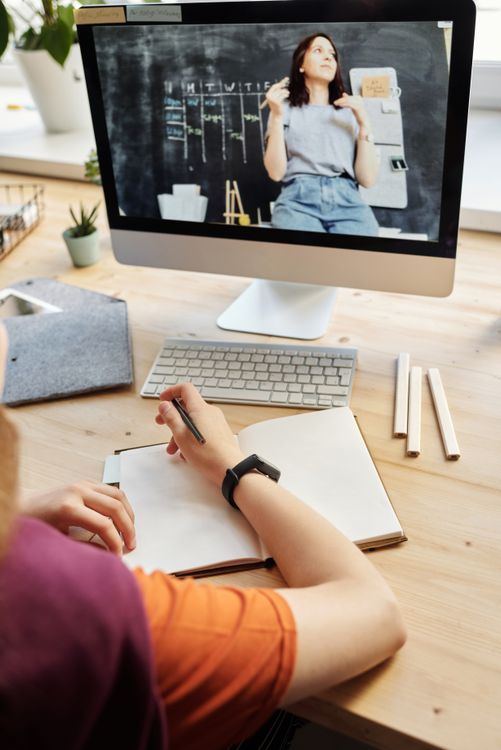 Person taking notes during free online course on screen